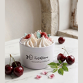 Handgemachte Sojawachskerze Kirschtraum von LichtleinLiebe in einer weißen Dose mit Kirsch-Topping, dekoriert mit frischen Kirschen auf einem weißen Marmortisch.