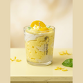 Zitronenwölkchen Sojawachskerze im Glas, Zitronen-Dessert-Kerze mit Zitronenscheibe, Sahnehaube und Blättern, Produktfoto auf hellem Hintergrund.