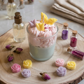 Handgefertigte Sojawachskerze "Tulpenwölkchen" im Glas, zweifarbig in Pastellgrün und Rosa mit aufgesetzten Wachs-Tulpen und Schmetterling, arrangiert auf einer Holzscheibe mit kleinen Gläsern voller Glitzerpartikel. ✨🌷
