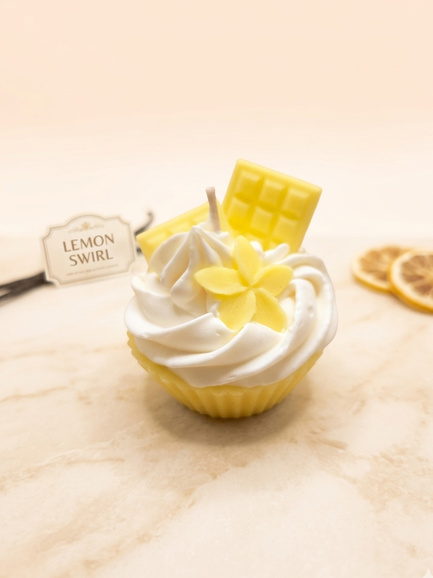 Handgegossene Vanille Cupcake-Kerze von LichtleinLiebe mit cremiger Sahnehaube auf rustikalem Holzuntergrund.